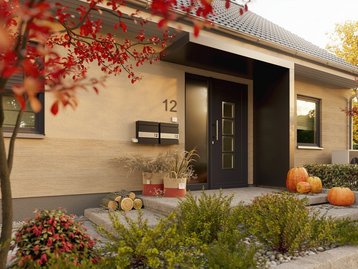 Eingangsbereich eines Einfamilienhauses im Herbst. Beispiel für einladende Architektur und flexible Hausgestaltung.