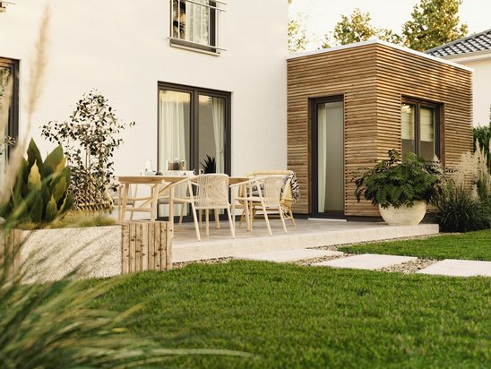 Stadthaus Flair 124 in Massivbauweise mit kubischer Architektur und großen Fensterflächen im grünen Garten.